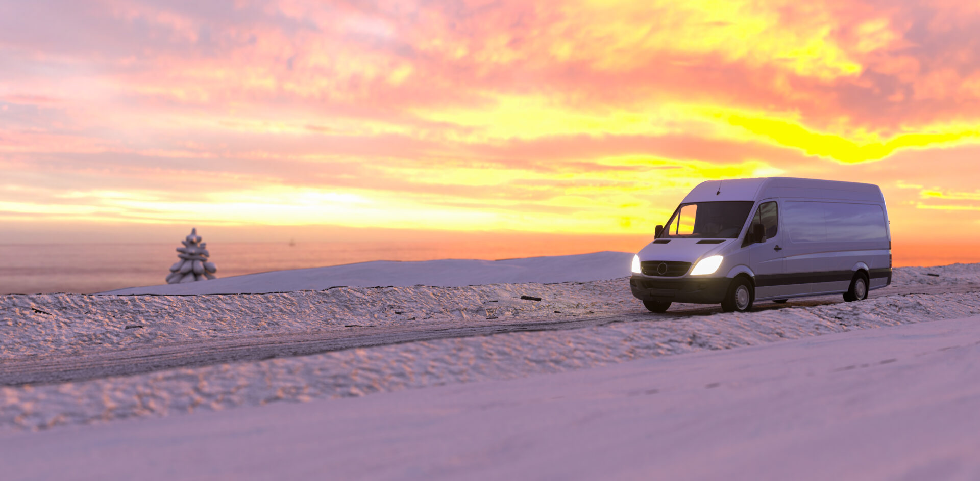 Weißer Transporter fährt bei Sonnenuntergang durch Winterlands